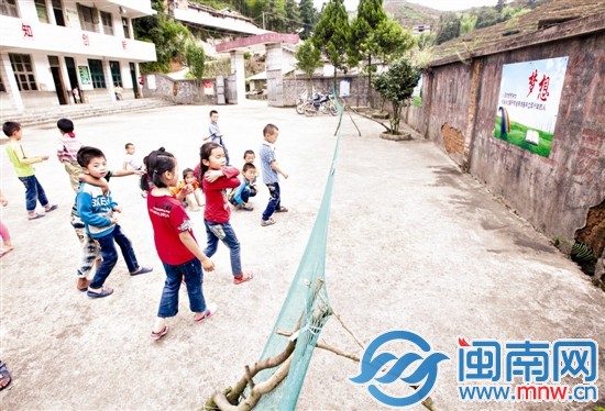 几名小学生在操场上玩，学校的围墙歪了一边，用简易 