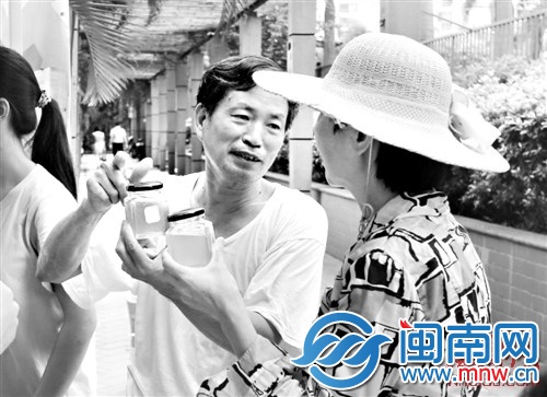 老蜂农(左)教市民如何鉴别蜂蜜真假