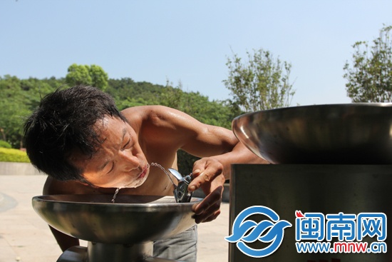 八仙山公园内，建筑工人周师傅正在直饮机旁喝水