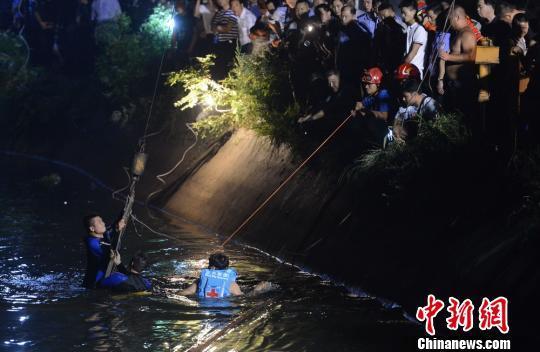 三位打捞人员正在将绳索捆绑于起重机上，以此拉出事 