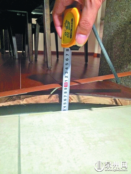 餐厅的木地板严重拱起变形，最高处近5厘米。（廖培煌 摄）