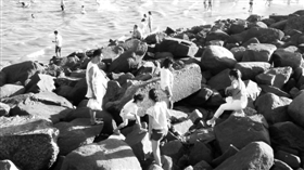 夏日海边玩耍勿在礁石攀爬