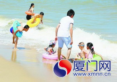 昨日，市民在环岛路海边戏浪消暑