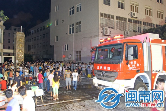 车间起火后，工厂员工撤离到厂房外