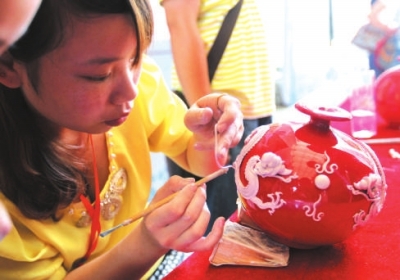 和陈春松师出同门的黄晓霞在现场展示漆线雕技艺。