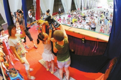掌中布袋戏培训班的小朋友在台上表演布袋戏《武松打 