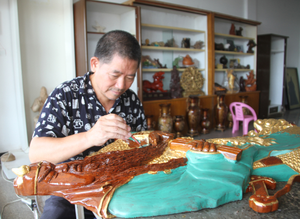 许庆石在制作关帝金木雕