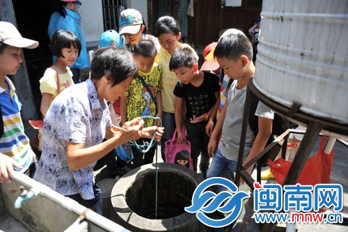 阿婆轻松就打上了一桶井水，小记者们看呆了