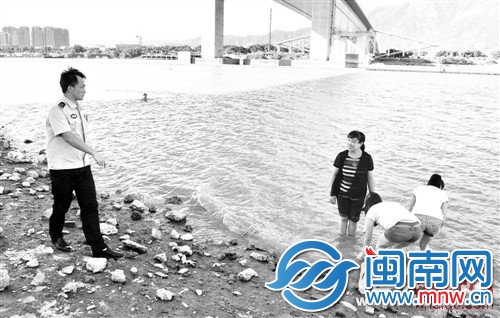 在事发地附近嬉水的市民被民警劝离