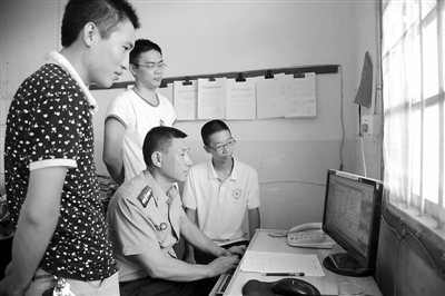 工作人员正指导返乡大学生进行网上征兵报名